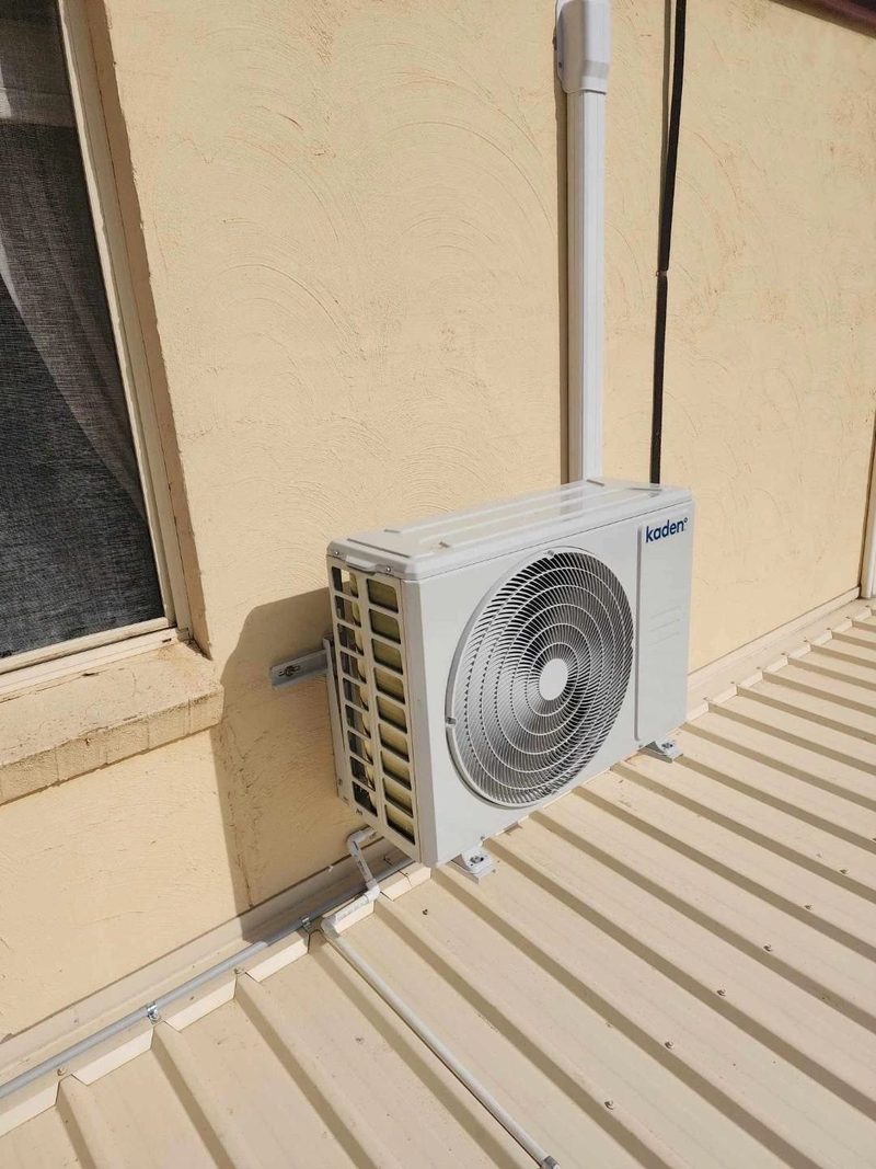 Outdoor unit bracketed above a Colorbond roof for airflow