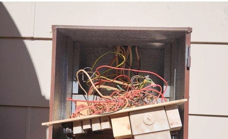 Unsupported, unterminated wiring crammed into the enclosure on an occupied house.